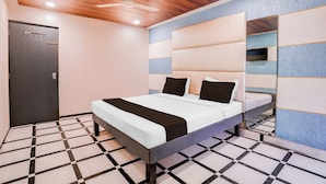 A modern bedroom with a bed, a door, and a ceiling fan. - Hotel O Palava Dombivali (Mumbai)
