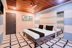 A hotel room with a bed, a ceiling fan, a door, and a wall with three framed pictures. - Hotel O Palava Dombivali (Mumbai)