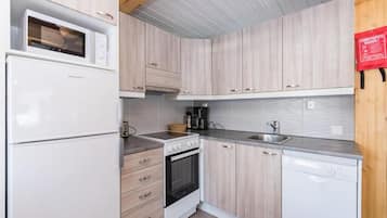 Eine kleine Küche mit Mikrowelle, Backofen und Geschirrspüler.