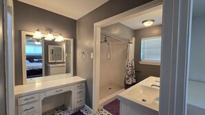 A bathroom with a vanity, mirror, shower, and a window with blinds. - Spacious 3BR Home for a Houston Getaway (Houston)