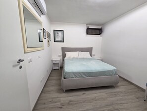 Ein Schlafzimmer mit einem Bett, einem Nachttisch und einem Spiegel.