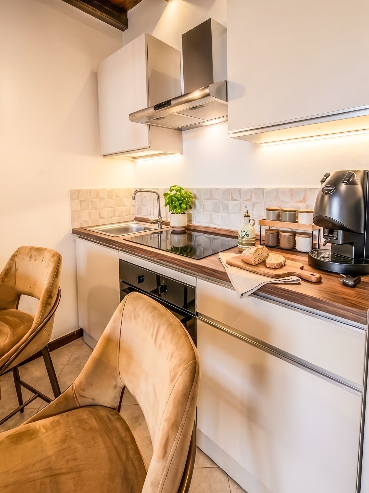 Eine moderne Küche mit Einbauherd, einer Kaffeemaschine und einem Blumentopf.
