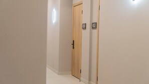 Un passadís amb una porta de fusta i dos senyals amb números, que indiquen els números de les habitacions.