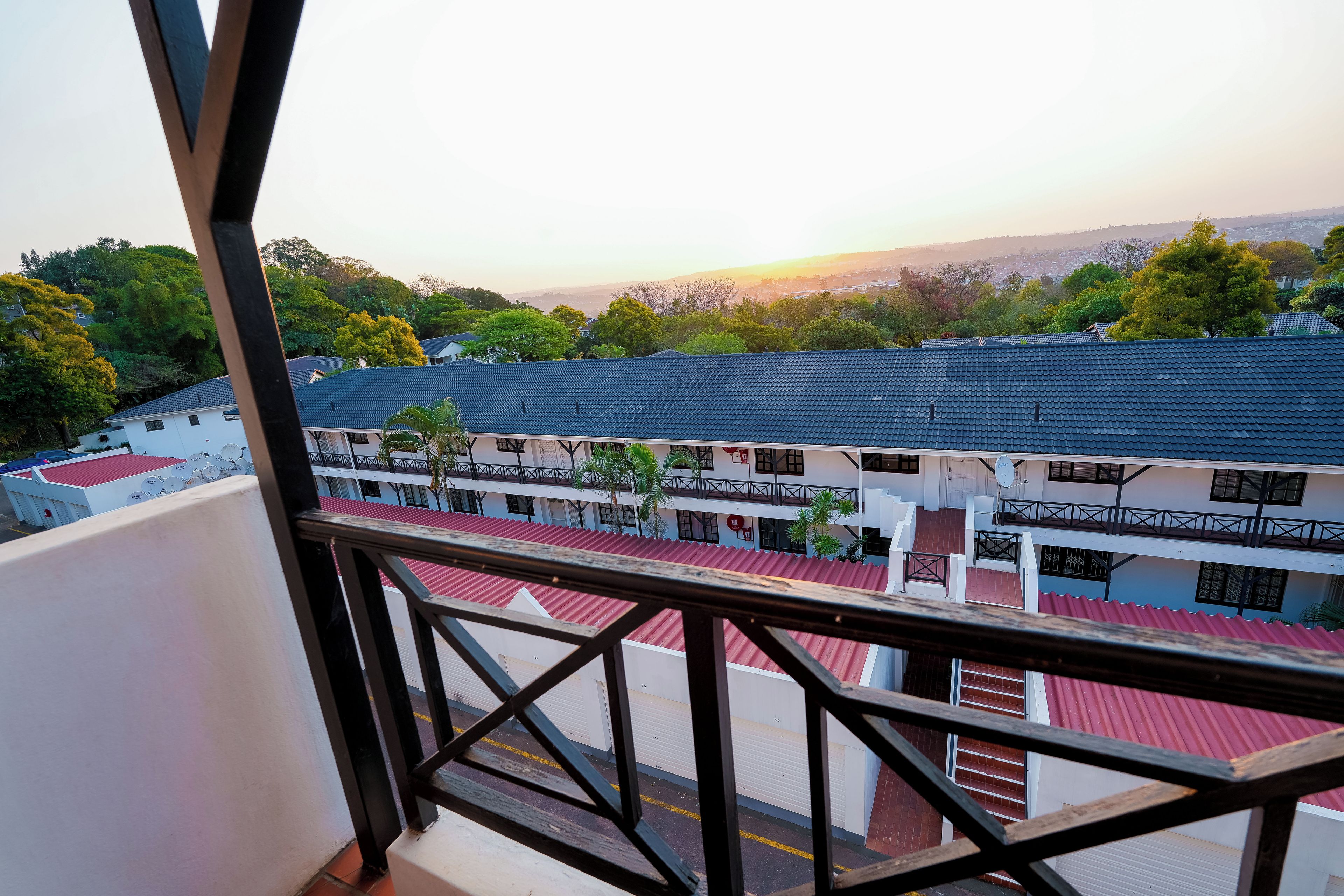 Un quartier résidentiel avec des immeubles à plusieurs étages, des balcons dotés de garde-corps et une vue sur le paysage environnant.