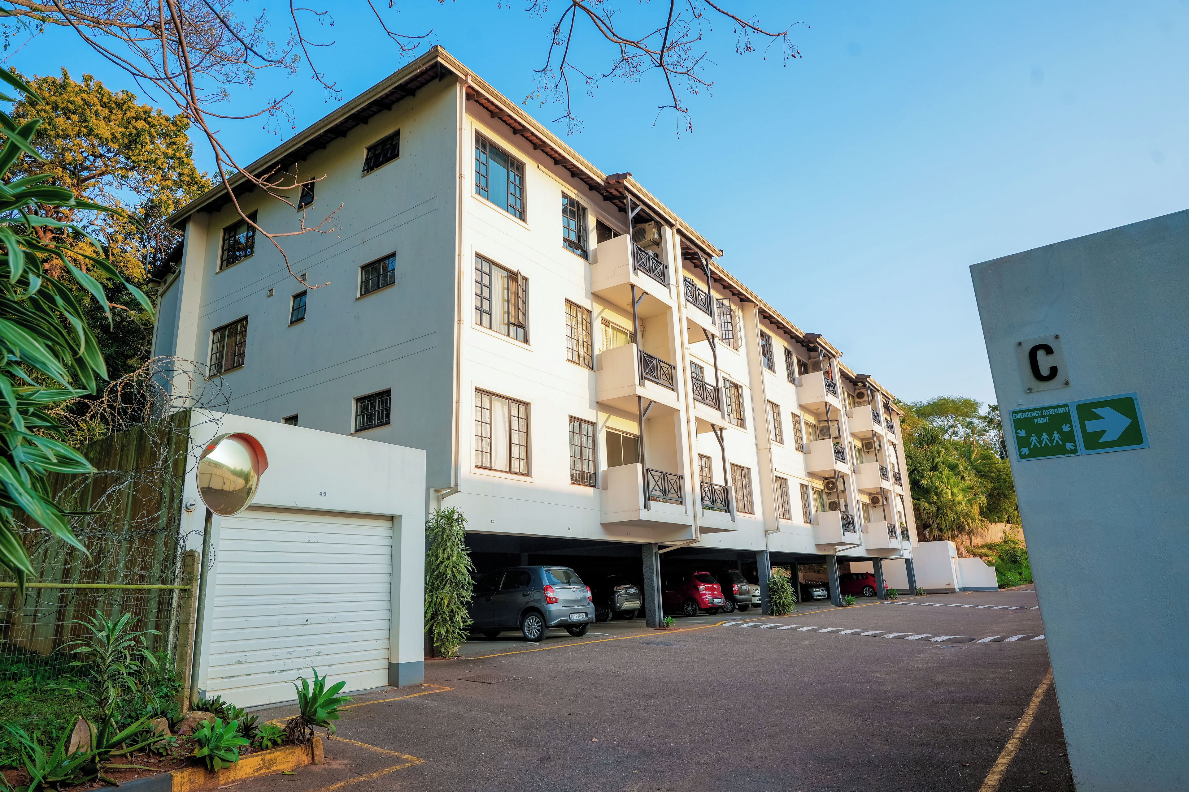 Un edificio residencial de varios pisos con zona de estacionamiento en garaje.