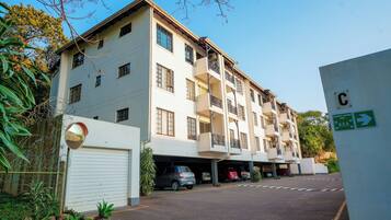 Un edificio residencial de varios pisos con zona de estacionamiento en garaje.