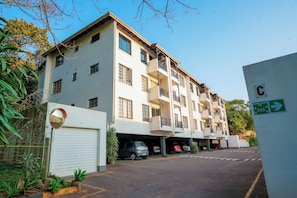 A multi-story residential building with a garage parking area.