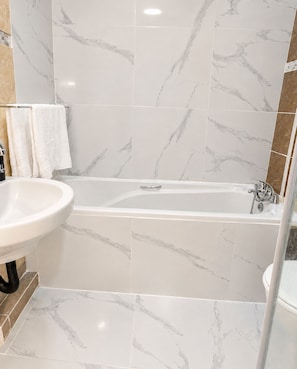 A bathroom with a bathtub, a sink, and a shower area. - Westridge Cozy Haven Fast WI-FI.Peace fully and comfortable (Berea)