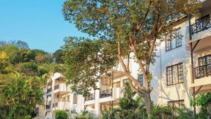 Un edificio a più piani con balconi e una strada di fronte.