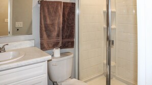Een badkamer met een wastafel, toilet en douchecabine met glazen wanden.