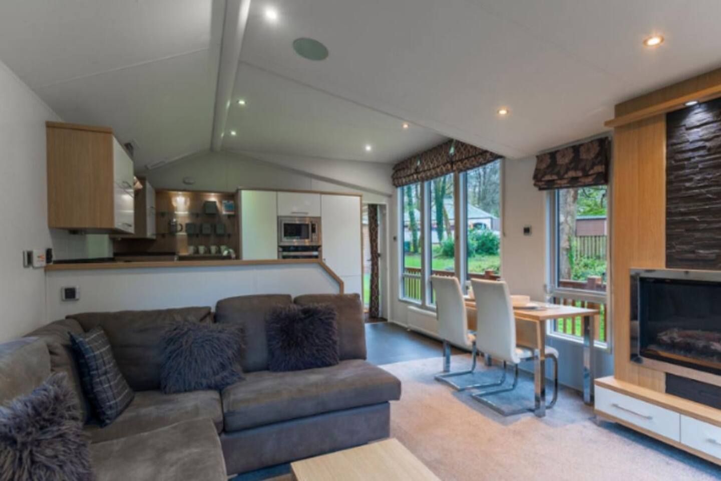 A modern living room with a sofa, a TV, and a dining area with chairs.