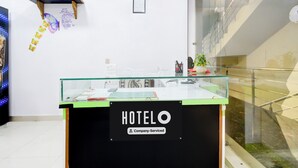 A hotel reception desk with a glass top and a sign reading 'HOTELO Company-Serviced'. - Super Hotel O Moula Ali Neredmet (Hyderabad)