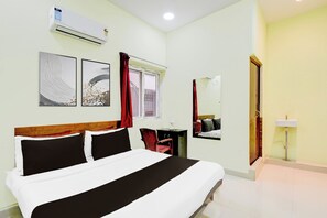 A hotel room with a bed, a desk, a chair, a window with curtains, a wall-mounted air conditioner, and a mirror. - Super Hotel O Moula Ali Neredmet (Hyderabad)