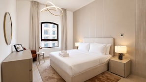 Een hotelkamer met een groot bed, nachtlampjes, een bureau en uitzicht op gebouwen door een raam.