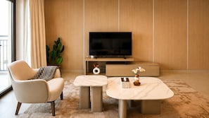 Een moderne woonkamer met een bank, salontafel en televisie.