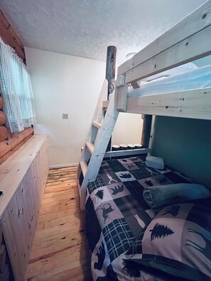 A bunk bed with a wooden ladder, a small wooden bench, and a patterned blanket. - Lighthouse Lodge-Lion's Head, Tobermory, The Grotto, Flowerpot, Bruce Trail (Lion's Head)