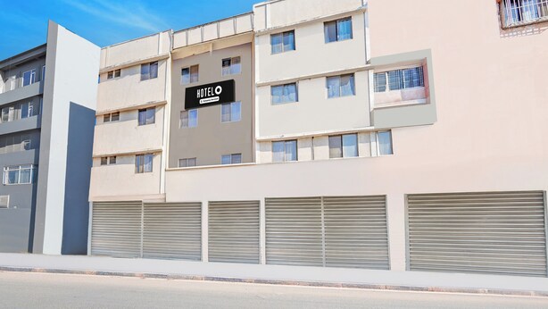 A multi-story hotel building with a sign indicating it is a company-serviced hotel. - Hotel O Rane Nagar (Nashik)