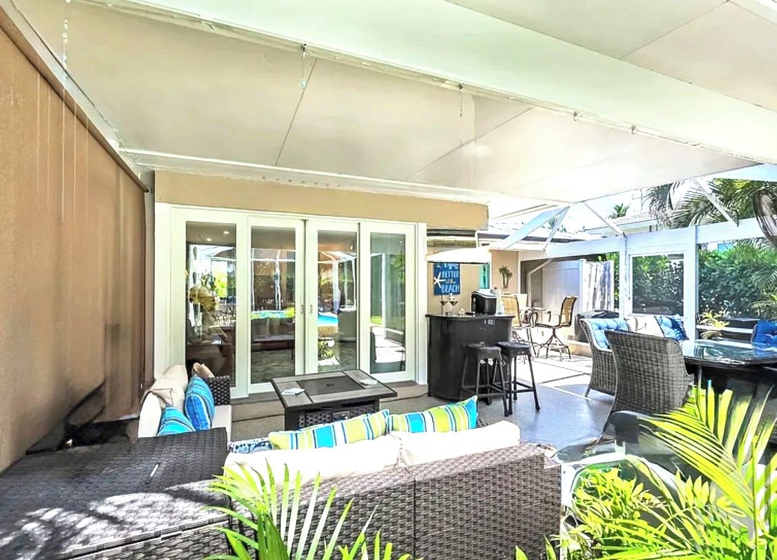 An outdoor patio area with a dining table, chairs, and a bar area.