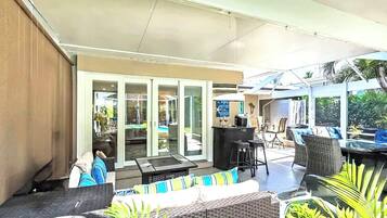 An outdoor patio area with a dining table, chairs, and a bar area.
