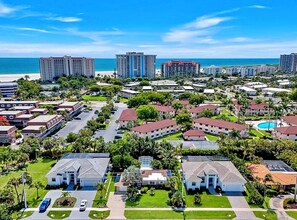 Une zone résidentielle côtière avec des immeubles à plusieurs étages, une plage et un ciel dégagé.