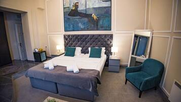 A hotel room with a large bed, two bedside tables, a chair, a painting, and a mirror.