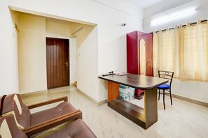 A room with a dining table, chairs, a red cabinet, and a door.