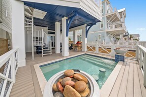 Ein Poolbereich mit Whirlpool, Holzterrasse und Sitzgelegenheiten im Freien.