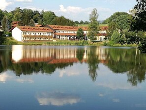A lakeside hotel with multiple buildings, a calm lake, and surrounding greenery. - 14th Floor With Panoramic Balcony and Lake View (Arrach)