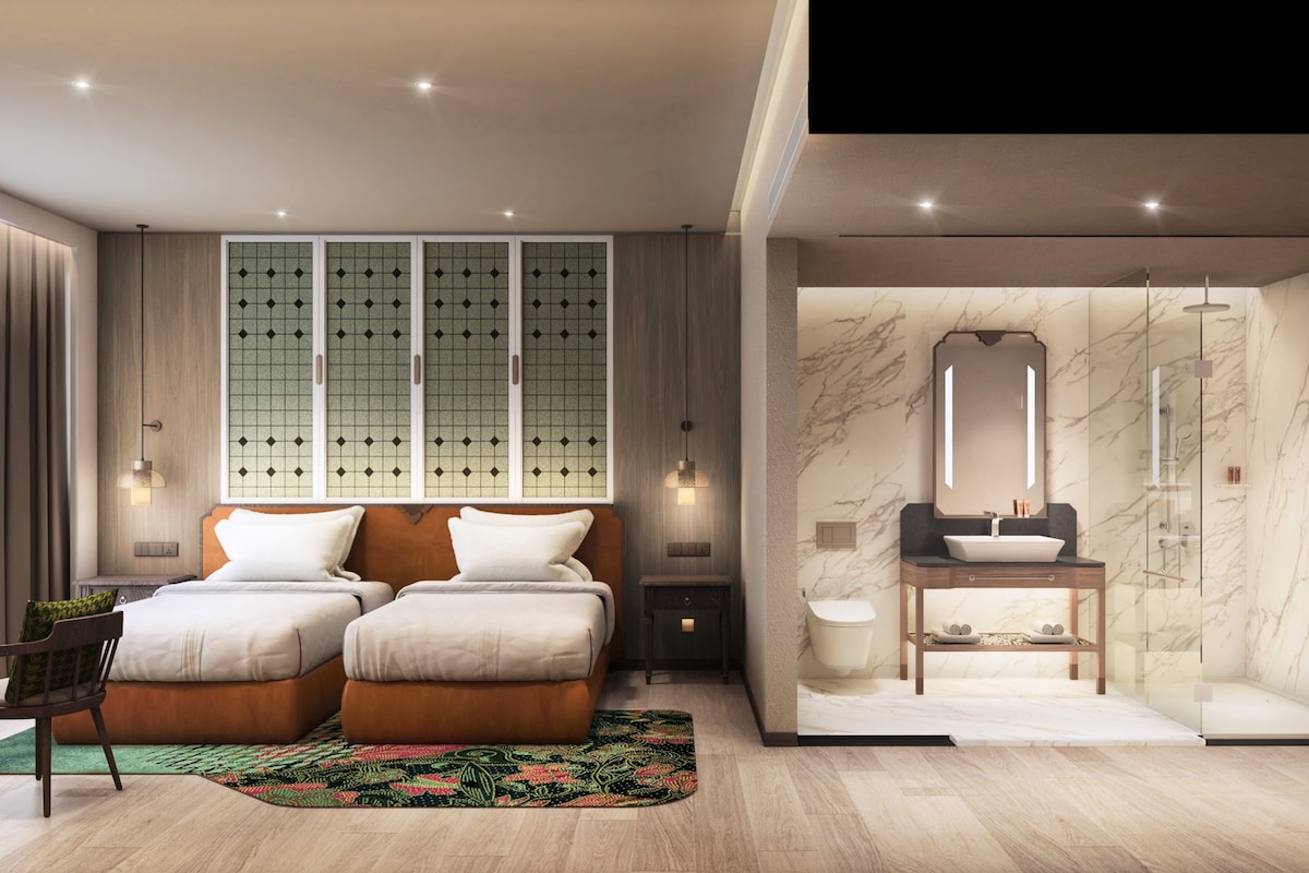 A modern bedroom with two beds, a large window with a grid pattern, and a bathroom with a marble sink and mirror.