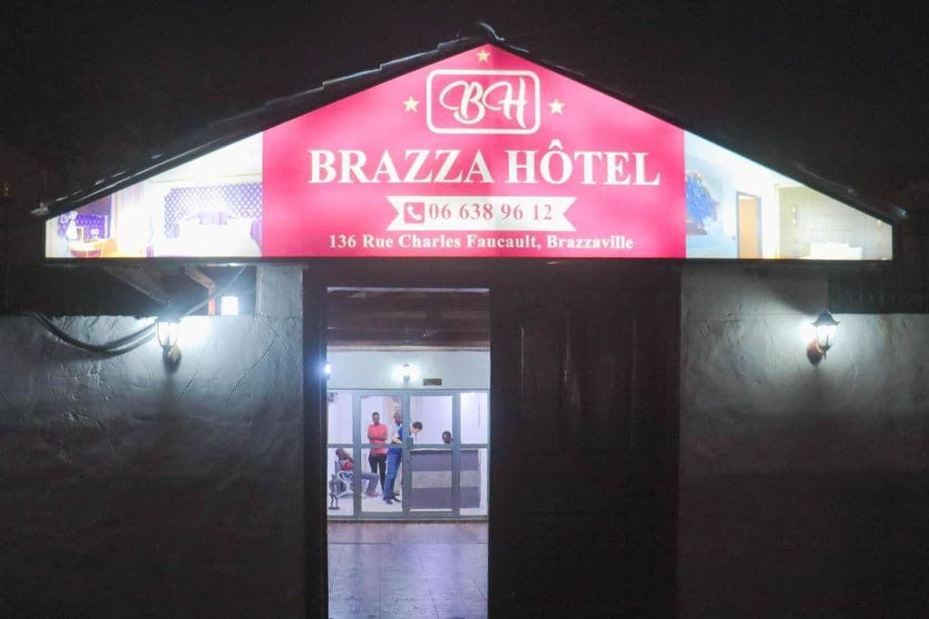 A hotel sign with the name 'BRAZZA HÔTEL' and a phone number.