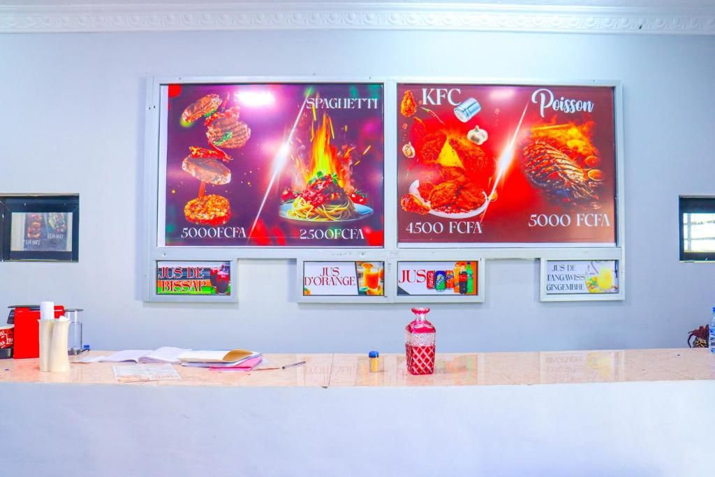Un mur orné de publicités pour des produits alimentaires et un comptoir où sont exposés divers articles.
