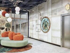 A modern interior with a seating area, a wall-mounted artwork, and a metallic door.