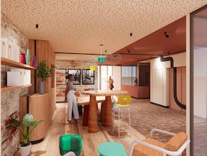 A modern interior with a brick wall, wooden shelves, a round table, and green and yellow chairs. - Ibis Styles Valence (ouverture Automne 2026) (Valence)