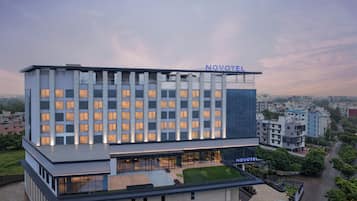 Un hotel moderno con tetto piatto, diversi piani e un cartello ben visibile con la scritta 'NOVOTEL'.
