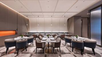 Een moderne vergaderzaal met ronde tafels, stoelen en inbouwverlichting.