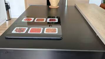Een keuken met een zwart aanrechtblad, houten kastjes en een potplant.