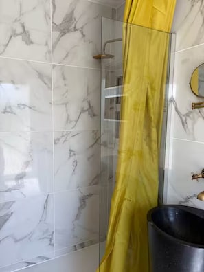 A bathroom with marble tiles, a shower enclosure, and a sink with a gold faucet. - Le Pignole · 2-bedroom apartment with AC and parking · Shared pool and garden · Sleeps 5 (Saint-Jory)