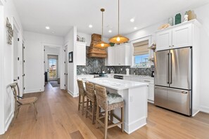 A modern kitchen with a central island, stainless steel appliances, and a herringbone backsplash. - New Listing! 2 Relax N is a luxury home offering gulf views, 2 master suites, 3 (Mexico Beach)