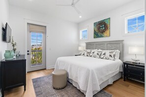 A bedroom with a bed, bedside tables, a nightstand, a window with a view, and a ceiling fan. - New Listing! 2 Relax N is a luxury home offering gulf views, 2 master suites, 3 (Mexico Beach)