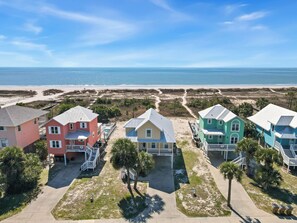 Una propiedad frente a la playa con casas coloridas, una playa de arena y el océano al fondo.