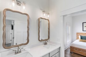 A bathroom with two large mirrors, a white sink, and a shower area. - NEW HOME! AMISTAD IS AN UPSCALE 6BD/4BA HOME W/GULF & CANAL VIEWS, PRIVATE POOL! (Mexico Beach)
