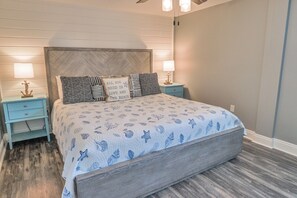 Ein Schlafzimmer mit einem Bett, zwei Nachttischen und einem Beistelltisch.