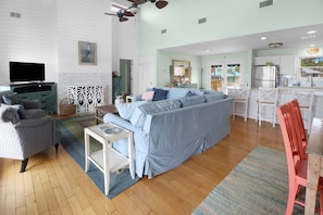 A spacious living room with a sofa, armchairs, and a television. - CABANA DEL SOL IS A 2BD/2BA GULF FRONT W/AMAZING VIEWS, 2 SCREEN PORCHES! (Port Saint Joe)