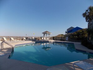 A clear blue pool with lounge chairs and a gazebo. - Cape it Simple -  OFFERS GULF VIEWS & STEPS TO THE BEACH! COMMUNITY POOLS! (Port Saint Joe)