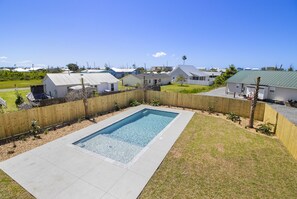 A residential area with a swimming pool, houses, and a clear sky. - THE "CRABBY HUNTER" IS A NEW HOME W/GULF VIEWS, PRIVATE POOL & OPTION TO RENT GO (Mexico Beach)