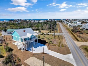 A single-story house with a blue roof and a red star on the front. - THE "CRABBY HUNTER" IS A NEW HOME W/GULF VIEWS, PRIVATE POOL & OPTION TO RENT GO (Mexico Beach)