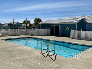 A swimming pool with a diving board, surrounded by a white fence, and a building with a blue exterior. - "Georgia Sand" is 600 steps to the beach! This 2BD/2BA adorable cottage sleeps 8 (Mexico Beach)