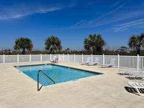 A rectangular swimming pool with a white fence and lounge chairs around it. - "Georgia Sand" is 600 steps to the beach! This 2BD/2BA adorable cottage sleeps 8 (Mexico Beach)