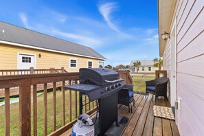 A deck with a barbecue grill, outdoor furniture, and a house in the background. - "Georgia Sand" is 600 steps to the beach! This 2BD/2BA adorable cottage sleeps 8 (Mexico Beach)