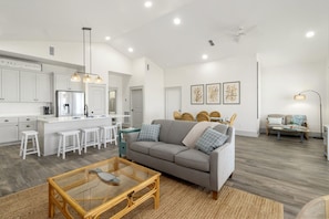 A modern living space with a kitchen, dining area, and seating area. - NEW LISTING! Grand Coral, a 4BD/2BA luxury home with a living/kitchen/dining are (Mexico Beach)